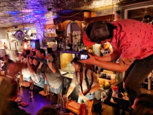 A camera man taking picture of bar tenders